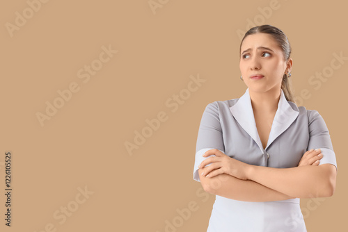 Thoughtful maid on beige ba...