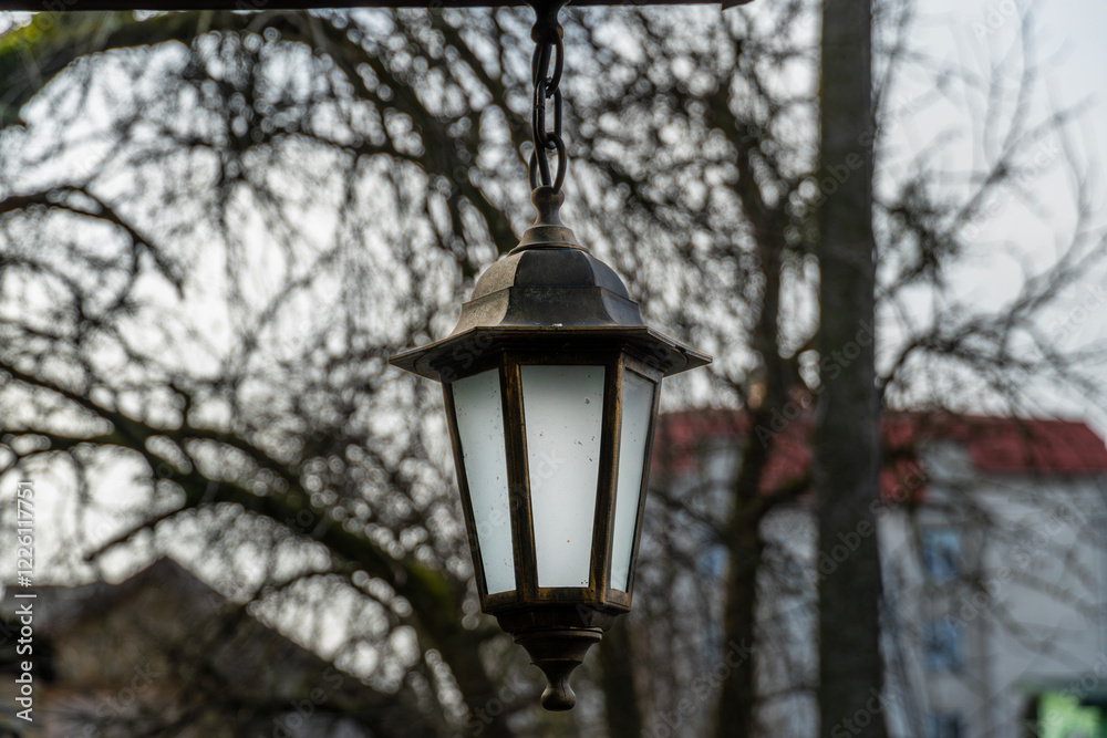 Old lantern hanging on the street, cozy warm autumn atmosphere Old lantern hanging on the street, cozy warm autumn atmosphere