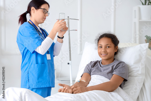 Teenage African-American girl with infusion drip and doctor in hospital room