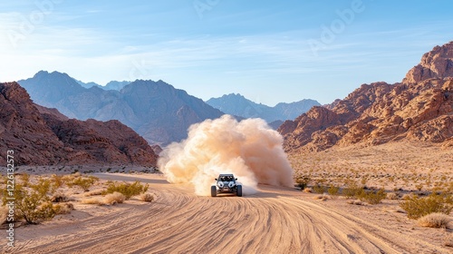 Desert dune buggy racing, dust cloud, mountain backdrop; adventure travel poster photo