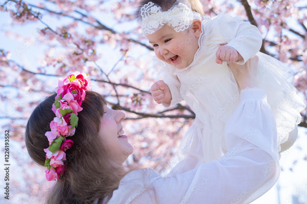 Obraz premium 桜を楽しむ赤ちゃんとお母さん