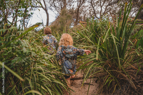 Two children exploring beachside bush