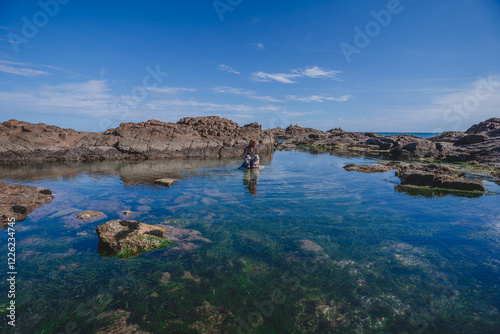 Family exploring water hole amongst rock pool
