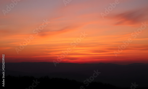 Orange sunset sky with distant mountain silhouettes. Perfect for nature-themed designs, travel brochures, outdoor adventure promotions, or inspirational content