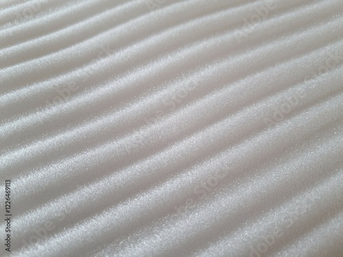 Texture of the surface of the embossed foam rubber of white color
