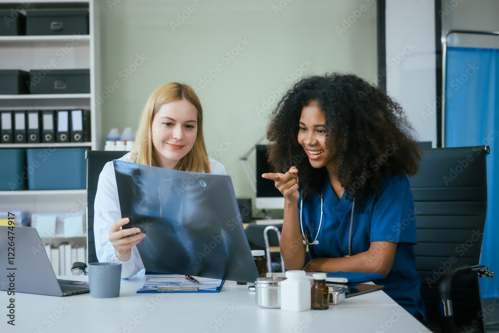 Fototapeta premium An African American female doctor and a white female doctor work at hospital desk, discussing patient treatment,medical analysis,healthcare strategies ensure quality medicine effective patient care