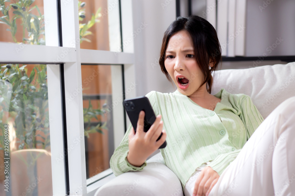 Asian young woman stress and worried sitting on sofa while speaking on smart phone in living room at home, woman unhappy and concerned talking on smartphone, lifestyle and communication. Asian young woman stress and worried sitting on sofa while speaking on smart phone in living room at home, woman unhappy and concerned talking on smartphone, lifestyle and communication.