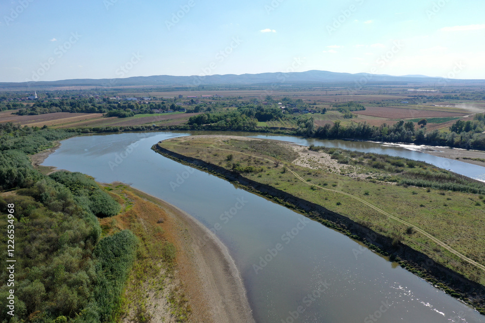 Obraz premium Flying over a river flowing on a plain aerial view