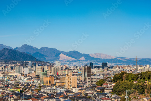 大分市市街地と遠くに見える鶴見岳の風景