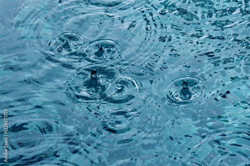 Photo of raindrops on the water. Puddles and raindrops. Circles on the water. 