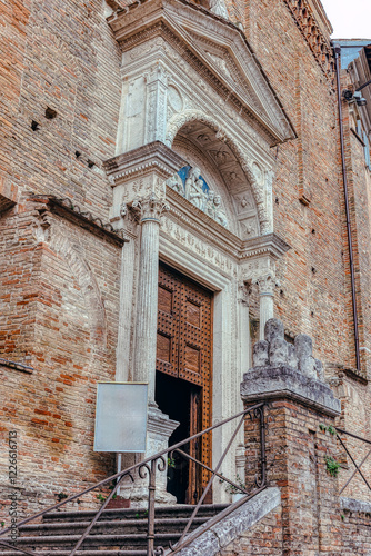 Obraz na płótnie The grand entrance of the Catholic Cathedral in Urbino features detailed stone carvings and a majestic wooden door. The steps leading to this historical site. w salonie