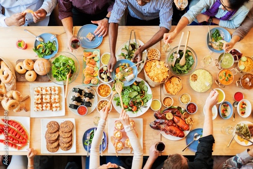Diverse group enjoying a colorful feast. Top view of a table filled with salads, seafood, and desserts. Hands reaching for food, sharing a vibrant meal together. Buffet table with delicious food.