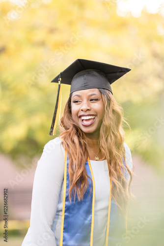 African Americna woman wearing graduation cap and laughing photo