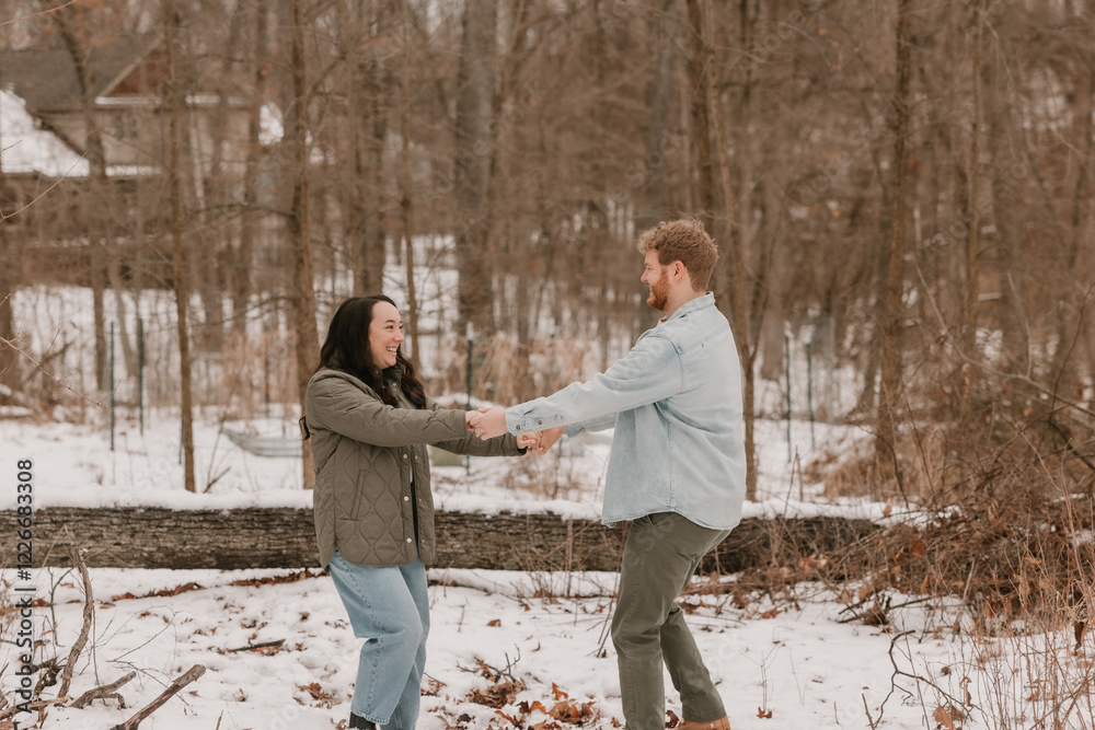 A happy couple enjoying a snowy day in a winter forest A happy couple enjoying a snowy day in a winter forest