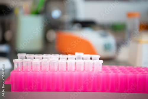 Clear plastic vials in pink holder rack in biotech science medical lab photo