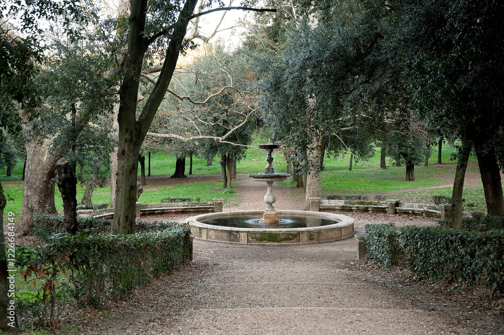 Elegant stone fountain in a lush, tree-filled park setting Elegant stone fountain in a lush, tree-filled park setting