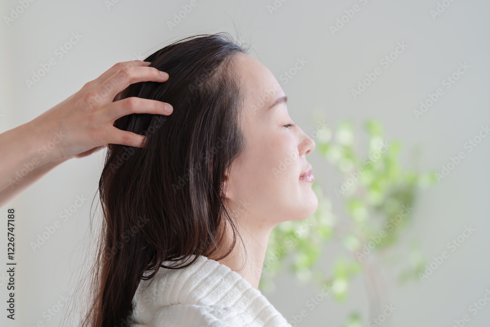 Fototapeta premium ヘッドマッサージの施術を受ける女性.