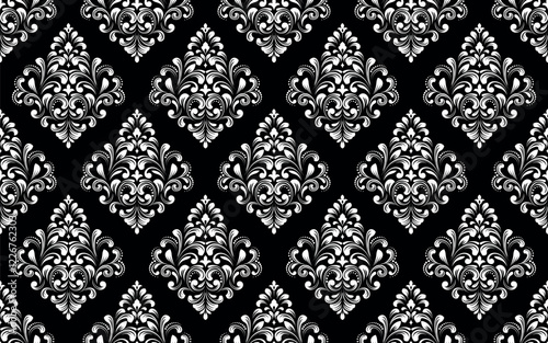 Wallpaper in the style of Baroque. Seamless vector background. White and black floral ornament. Graphic pattern for fabric, wallpaper, packaging. Ornate Damask flower ornament.