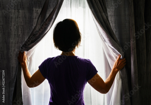 Obraz na płótnie Woman opening the curtains and letting morning sunlight in. Bright sunny day outside. w salonie