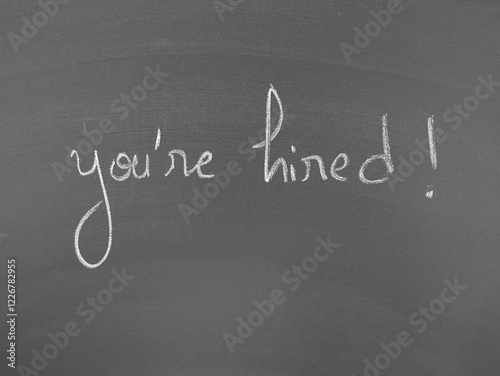 You're hired written on a chalkboard surface in white lettering photo