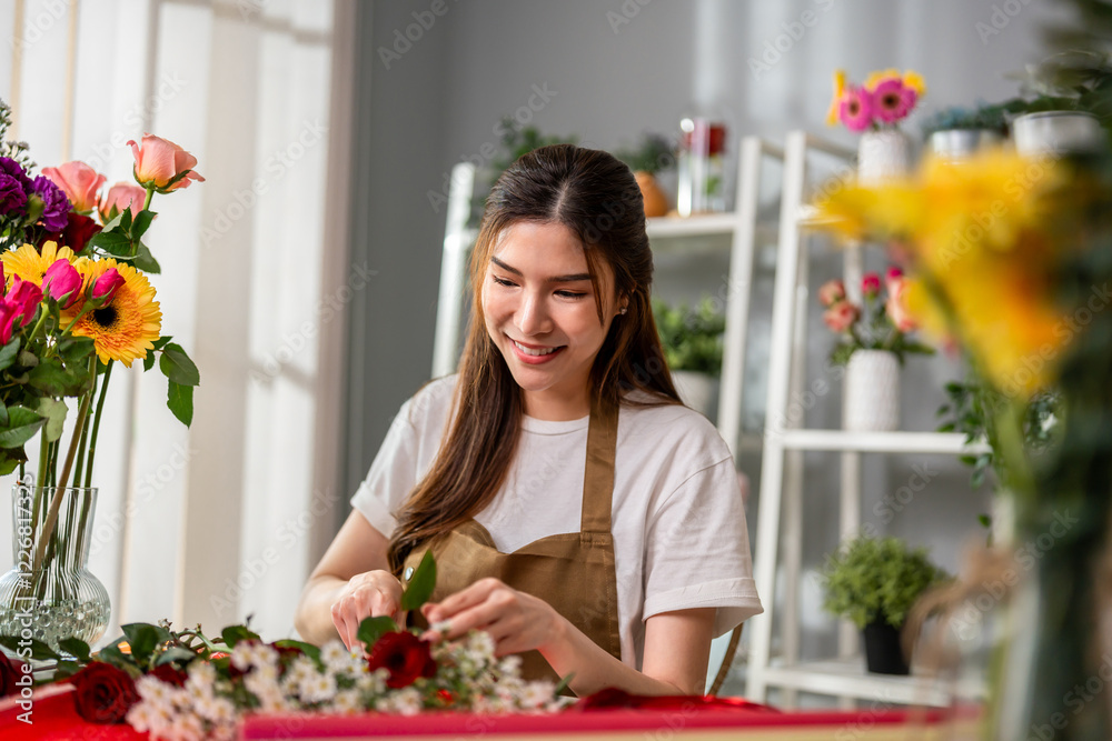 Asian young florist girl completing beautiful bouquet in flower shop. Asian young florist girl completing beautiful bouquet in flower shop.