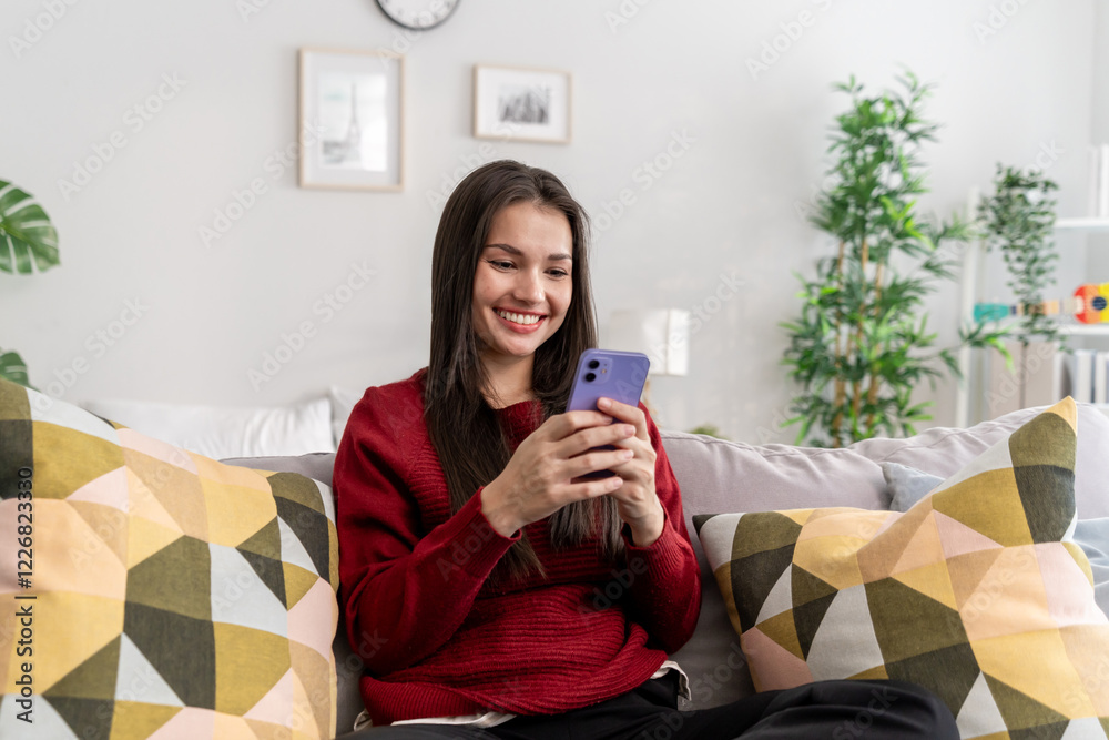 Asian beautiful woman sitting on sofa and swipe mobile phone in house. Asian beautiful woman sitting on sofa and swipe mobile phone in house.