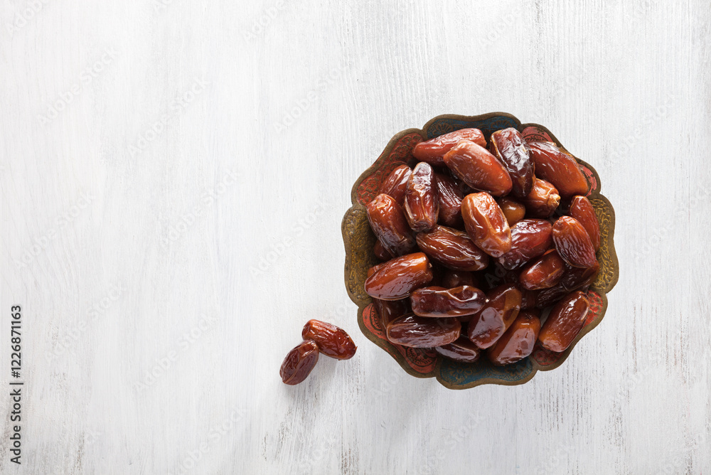 Bowl of  dates  on  white  wooden background. Top view.
