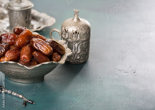 Obraz na płótnie Bowl full of dates, cup of coffee and misbaha on blue-green wooden background w salonie