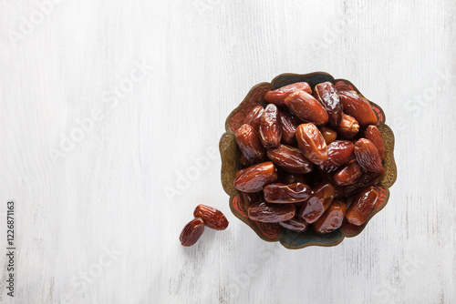 Obraz na płótnie Bowl of dates on white wooden background. Top view. w salonie