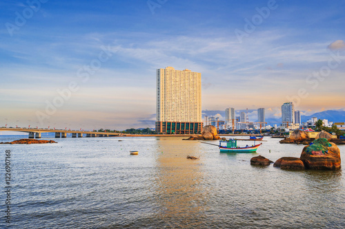 View of the Kei River with fishing boats against the backdrop of Urban view in north district of Nha Trang city, Vietnam. photo