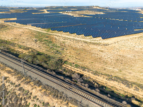 This stunning aerial shot captures an extensive solar panel array in an arid landscape, showcasing the shift towards renewable energy and sustainable practices in today's world. photo