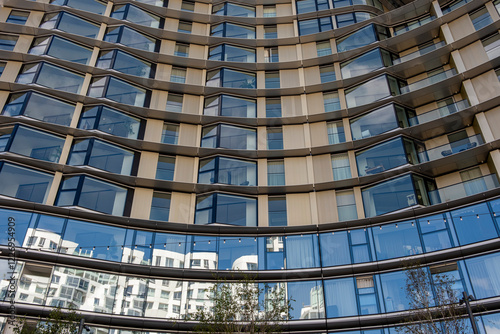 Apartment facade in London rise against the urban skyline, reflecting the city's dynamic mix of architecture. These residential buildings showcase modern living in a bustling metropolis, blending sty photo