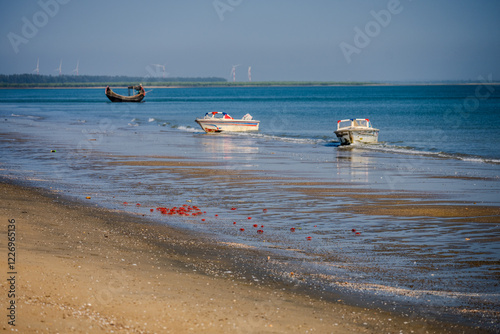 Fishing Boats Docked on Sandy Shoreline with Red Crabs and Distant Wind Turbines at Moheskhali Upazila, Cox's Bazar, Bangladesh