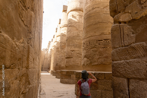 Tourist Immersed In The Beauty Of The Luxor Temple Surrounded By Stunning Ancient Artifacts photo