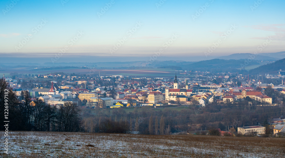 Aerial view of Moravska Trebova with its scenic panorama. The town is surrounded by rolling hills and dense forests, showcasing the harmony of historic architecture and Czech nature