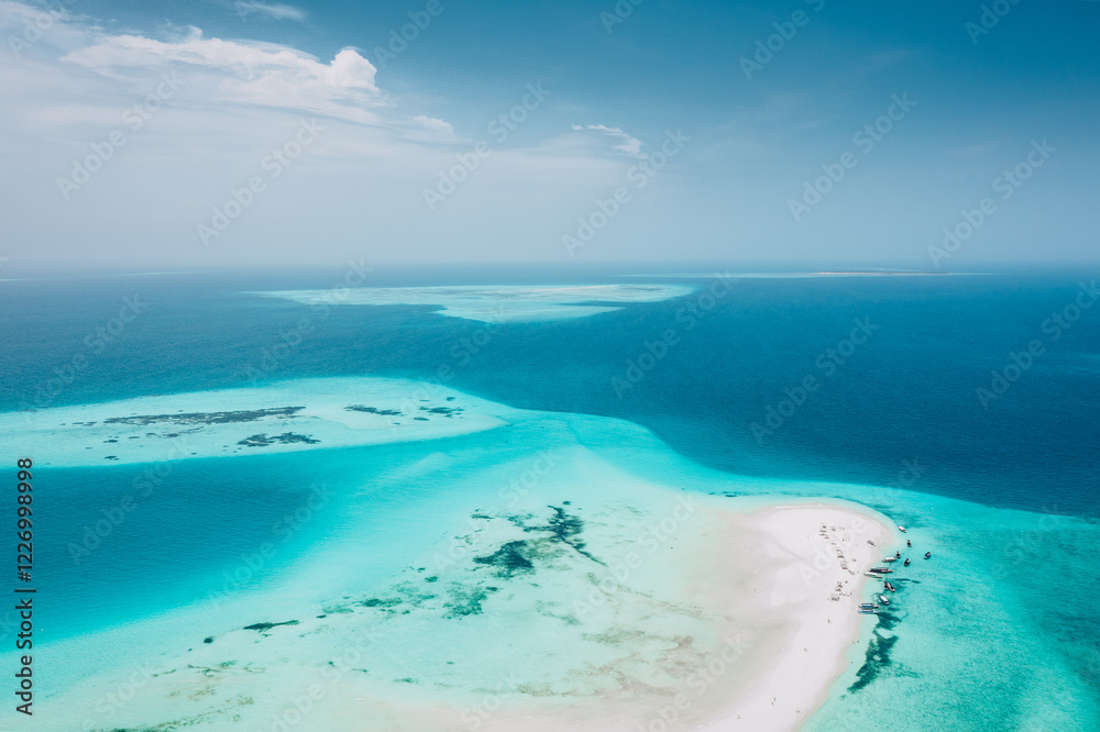Zanzibar, Aerial view of turquoise lagoon, white sand beach, and boats.