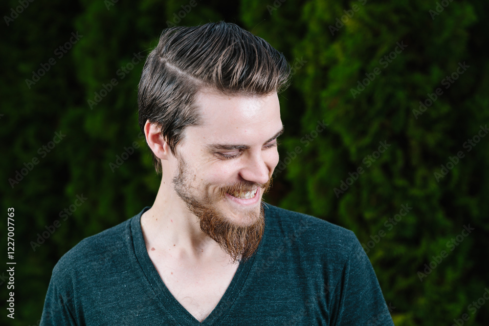 Close-up portrait of a smiling man standing in front of a hedge Close-up portrait of a smiling man standing in front of a hedge