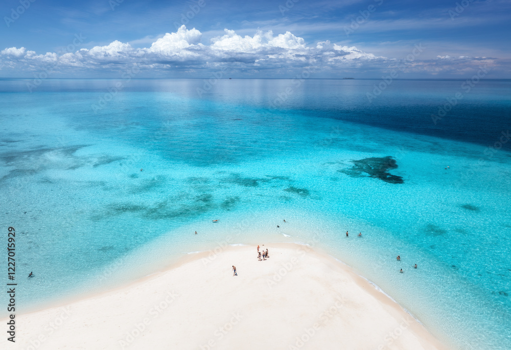 Fototapeta premium Aerial view of Nakupenda island, sandbank in ocean, white sandy beach, blue sea during low tide on sunny summer day. Zanzibar. Top view of sand spit, clear water, people, sky with clouds. Tropical
