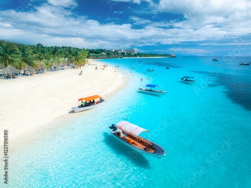 Fototapeta Naklejka Na Ścianę i Meble -  Aerial view of the boats on tropical sea coast with white sandy beach on summer sunny day. Vacation in Kendwa, Zanzibar. Landscape with boat, yacht, clear water, green palms, blue sky. Top drone view
