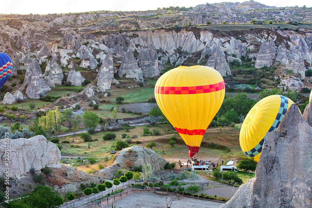 Hot air balloons gracefully rising over the unique rock formations of Cappadocia at sunrise