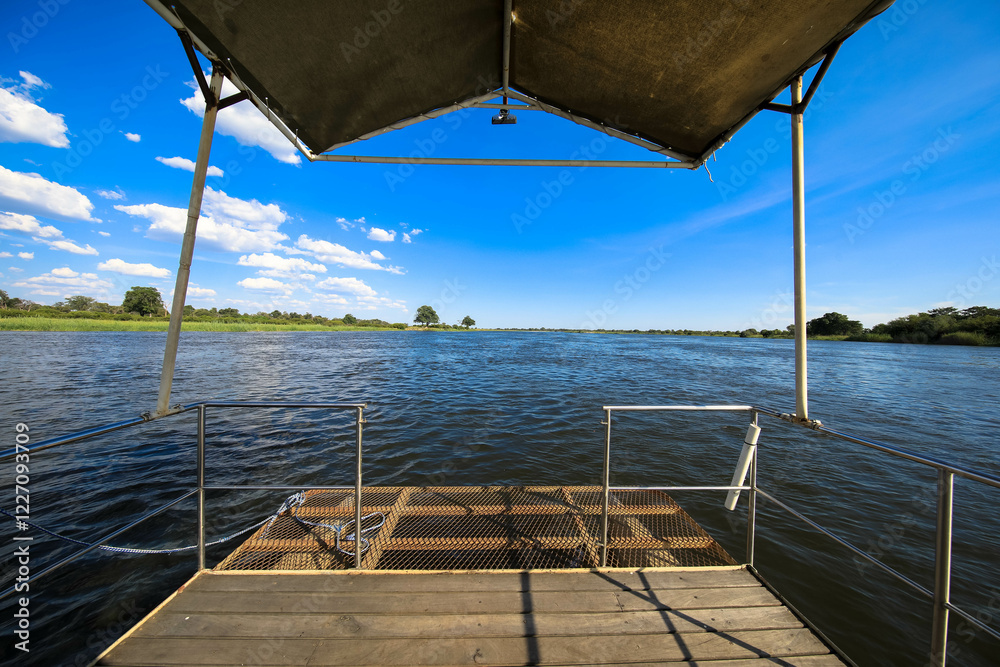 Obraz premium Spectacular panoramic views of the Okavango River and wetlands. Green vegetation on the river bank. Seen on a safari river cruise. Near Divundu and Mahango National Park. Namibia, Africa. 