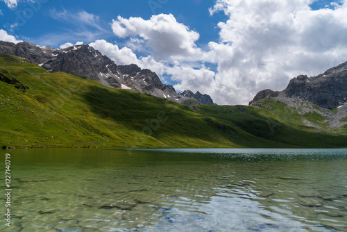 Wallpaper Mural Serene beauty of Savoie in the French Alps with this stunning photograph. Featuring lush green meadows, a winding stream, and towering snow-capped peaks against a clear blue sky Torontodigital.ca