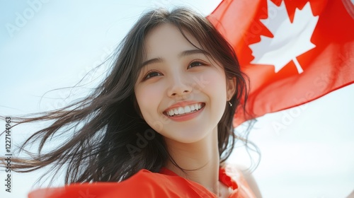 Happy young Asian woman with a Canadian flag on a white background photo