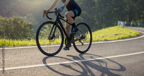 Woman cyclist riding bike in summer park