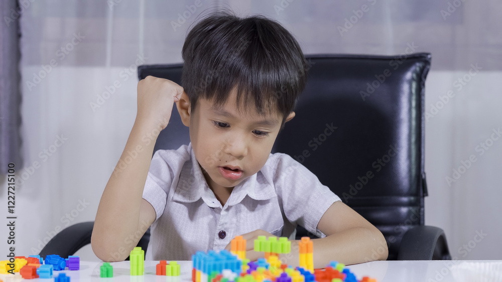 A little Boy  playing with colorful bricks in the living room, little Boy  playing with colorful toys.