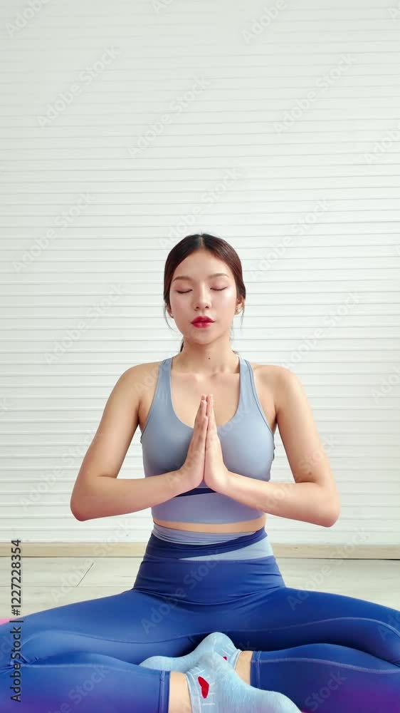 Zoom-in an Asian young woman practices yoga in a serene indoor space, showcasing mindfulness and tranquility. Woman workout or exercise at home. Vertical real-time 4k video. Zoom-in an Asian young woman practices yoga in a serene indoor space, showcasing mindfulness and tranquility. Woman workout or exercise at home. Vertical real-time 4k video.