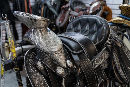 Silver and black leather riding saddle at store in Mexico. Horseriding equipment concept photo