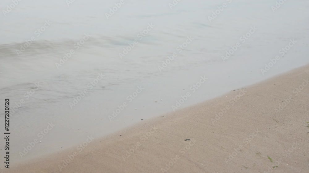 Calm waves gently washing a sandy beach of the baltic sea in Estonia