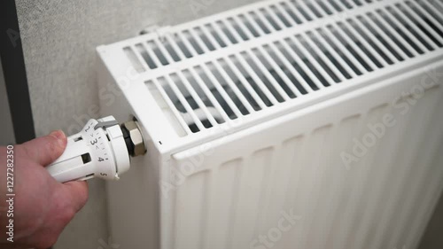 Wallpaper Mural A man adjusts the temperature on a heating radiator in an apartment. Torontodigital.ca