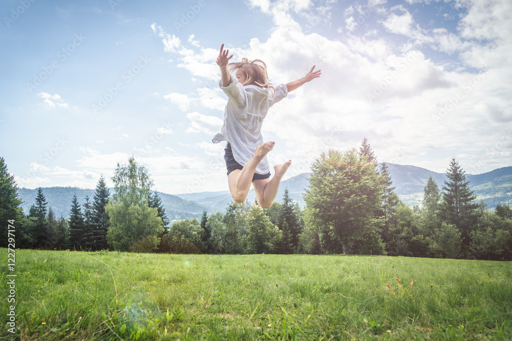 Happy young woman jumping on the meadow in mountains. Happy young woman jumping on the meadow in mountains.